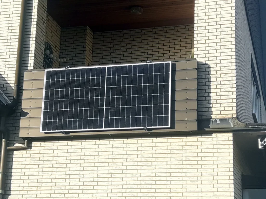 Kompakte Solarlösung an einem Wohnhausbalkon. Das Modul ist platzsparend montiert und zeigt, wie auch kleinere Flächen zur eigenen Stromerzeugung genutzt werden können.