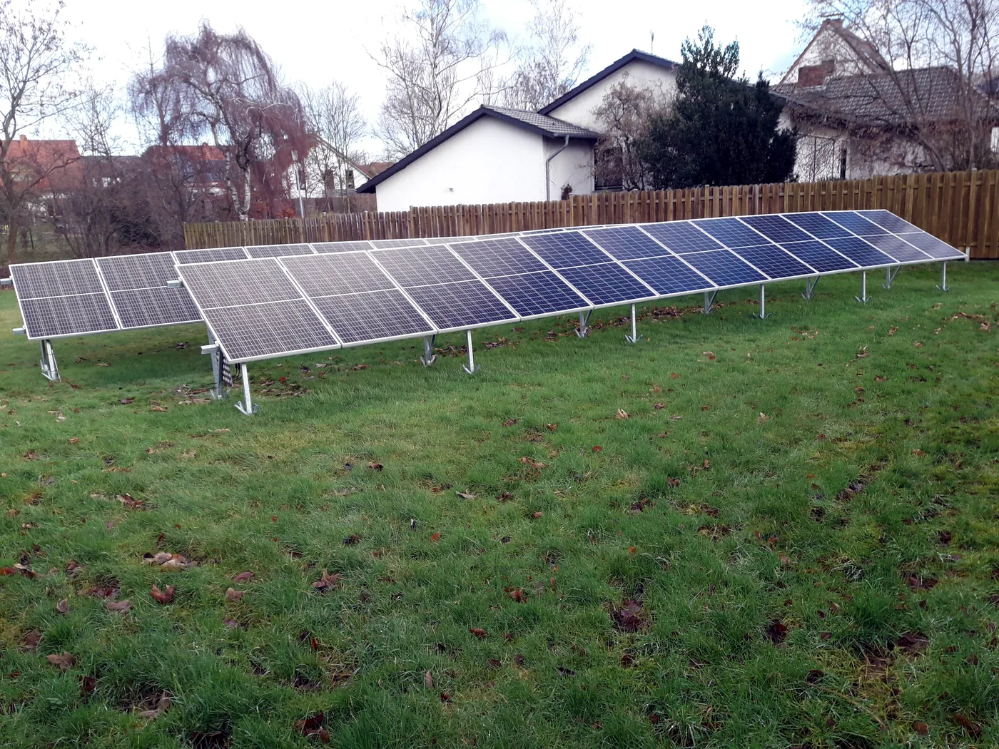 Kleine aufgestellte Photovoltaikanlage im Gartenbereich. Das Motiv zeigt eine einfache Lösung für geeignete Außenflächen, wenn eine Montage am Dach oder Balkon nicht im Vordergrund steht.