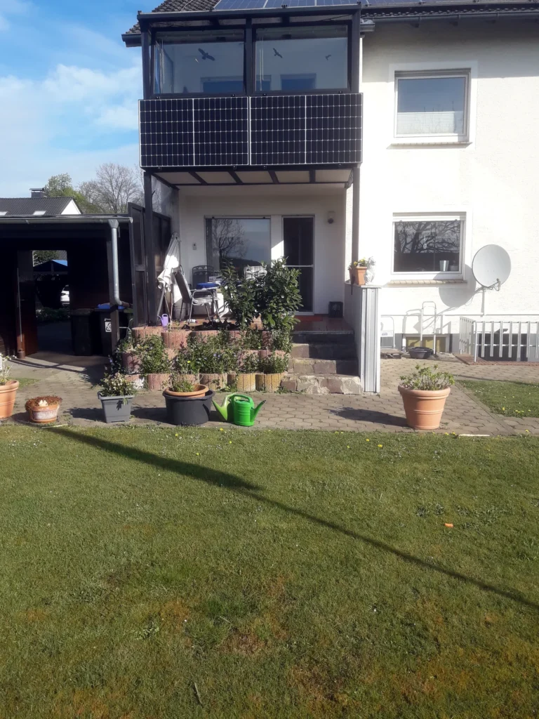 Balkonkraftwerk an einem Einfamilienhaus mit Garten. Die kompakte Anlage fügt sich unauffällig in das Wohnumfeld ein und nutzt die vorhandene Balkonfläche.