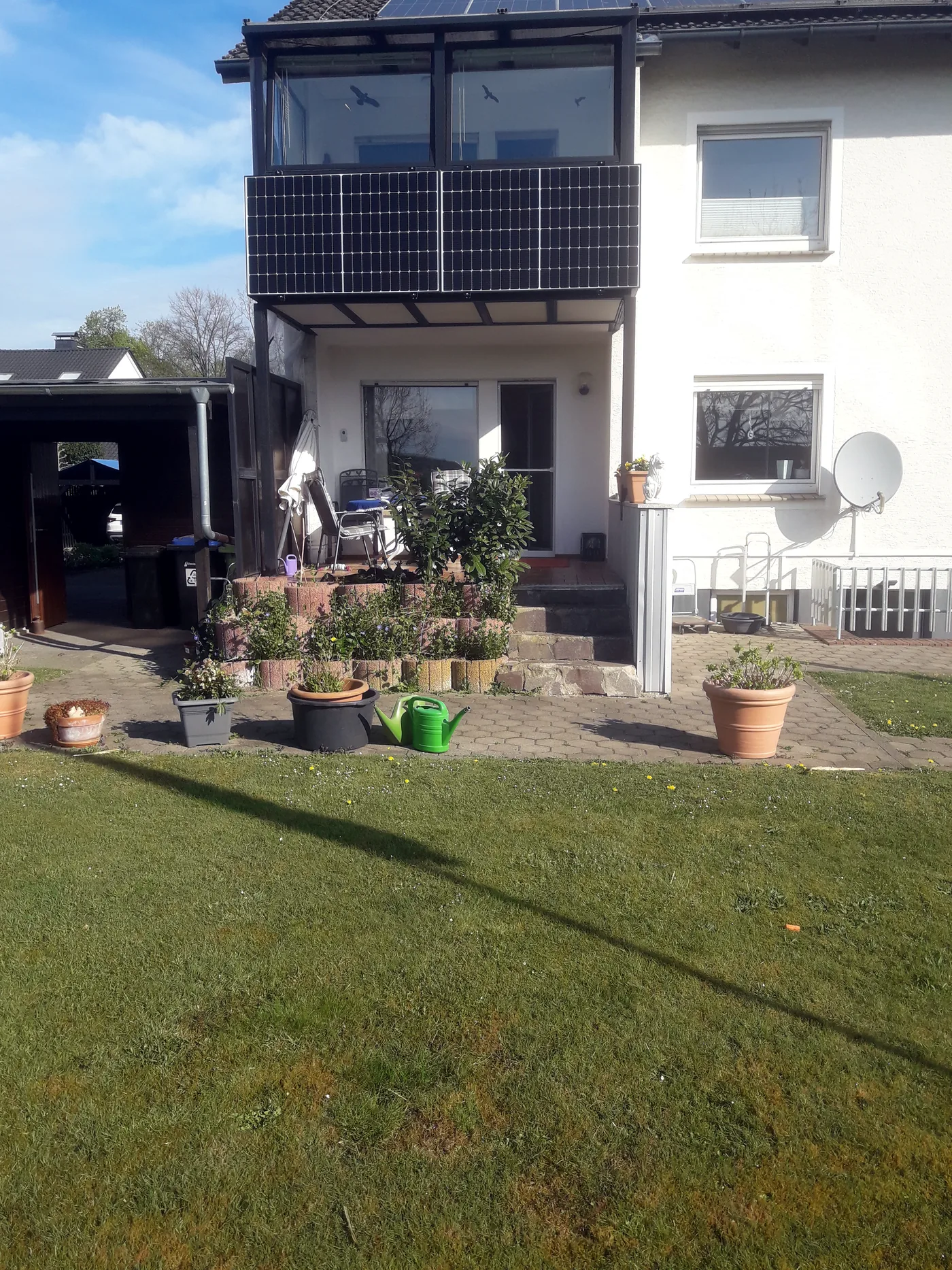 Balkonkraftwerk an einem Einfamilienhaus mit Garten. Die kompakte Anlage fügt sich unauffällig in das Wohnumfeld ein und nutzt die vorhandene Balkonfläche.
